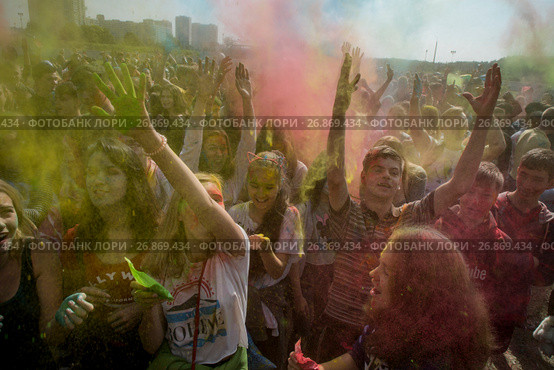 Посетители музыкального фестивале индийских красок ColorFest бросают друг друга сухой краской на конкурном стадионе в Битце города Москвы, Россия (2017 год). Редакционное фото, фотограф Николай Винокуров / Фотобанк Лори