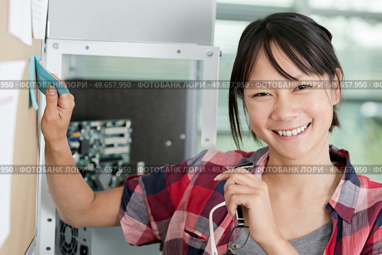 positive woman sticking sticky notes on a wall chart. Стоковое фото, агентство Ingram Publishing / Фотобанк Лори