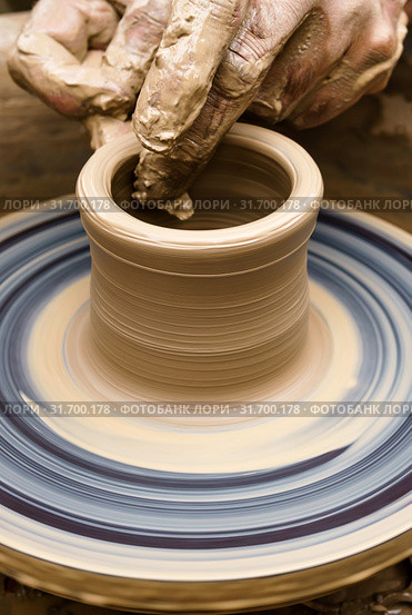 Potter's hands mold pottery on a rotating wheel. Стоковое фото, фотограф Евгений Харитонов / Фотобанк Лори