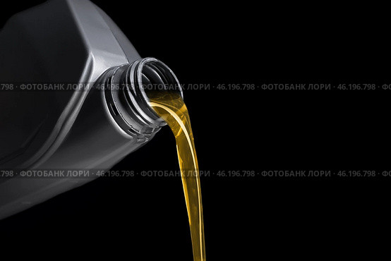 Pouring of motor oil from canister against black background, closeup. Стоковое фото, фотограф Pixel_shot / Фотобанк Лори
