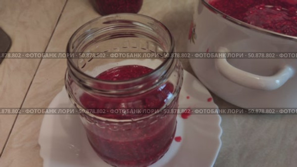 Pouring the finished crushed raspberries with sugar into jars. Homemade preparation of crushed raspberries with sugar. Стоковое видео, видеограф Андрей Жигальцов / Фотобанк Лори