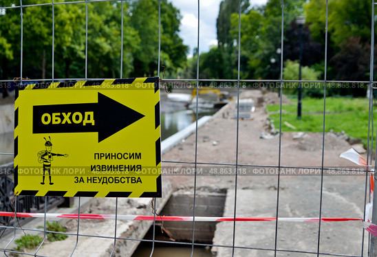 Предупреждающая табличка на строительном объекте  с указателем: «Обход. Приносим извинения за  неудобства” (2019 год). Редакционное фото, фотограф Snezka / Фотобанк Лори
