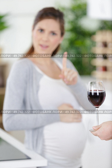 pregnant woman rejecting alcohol at home. Стоковое фото, агентство Ingram Publishing / Фотобанк Лори