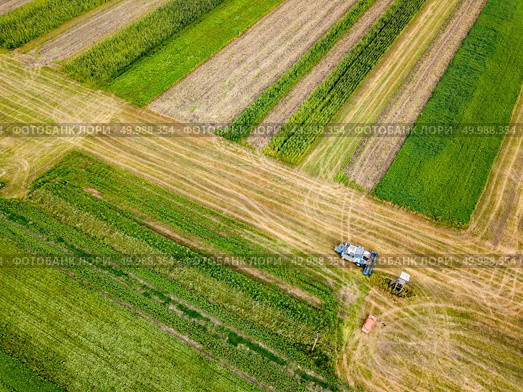 Preparation of soil for sowing of winter crops. Aerial view from the drone of the field after harvest with combine and red car on it.. Aerial view frome a drone of combine plowing the ground after harvesting on the field in the autumn time. Стоковое фото, агентство Ingram Publishing / Фотобанк Лори