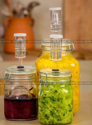 Preparing fermented preserved vegetables. Jars of cabbage kimchi and sauerkraut sour cabbage. . Стоковое фото, агентство Ingram Publishing / Фотобанк Лори
