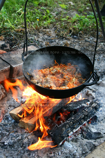 Приготовление плова на костре в казане. Мясо тушится с луком и морковью. Стоковое фото, фотограф Щеголева Ольга / Фотобанк Лори