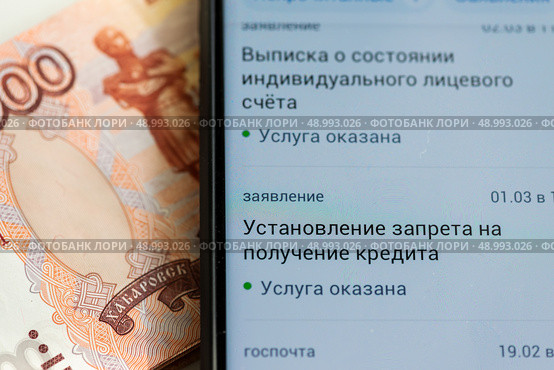 Приложение "Госуслуги" и купюры. Установление запрета на получение кредита. Редакционное фото, фотограф Игорь Низов / Фотобанк Лори