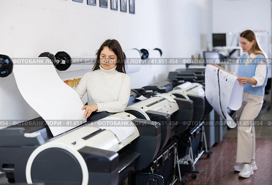 Print worker controlling printing process on modern offset machine in print shop. Стоковое фото, фотограф Яков Филимонов / Фотобанк Лори