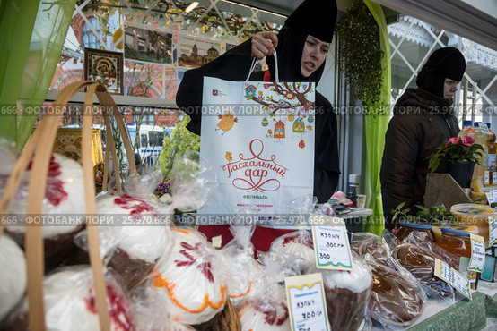 Продажа пасхальных куличей, выпечки, меда из православного монастыря на площади Революции в городе Москве во время ежегодного московского фестиваля "Пасхальный дар", Россия (2017 год). Редакционное фото, фотограф Николай Винокуров / Фотобанк Лори