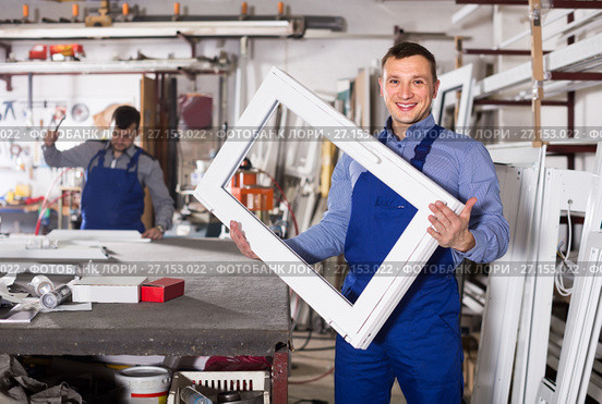 Production workers in coverall with different finished PVC profiles and windows at factory. Стоковое фото, фотограф Яков Филимонов / Фотобанк Лори