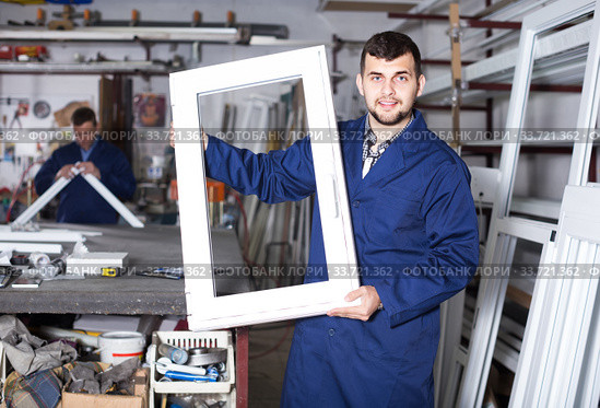 Production workers in coverall with different finished PVC profiles and windows at factory. Стоковое фото, фотограф Яков Филимонов / Фотобанк Лори