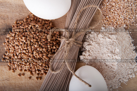 Products made from buckwheat on a wooden table close-up: noodles (soba), buckwheat, flour and cereals. Стоковое фото, фотограф Olesya Tseytlin / Фотобанк Лори
