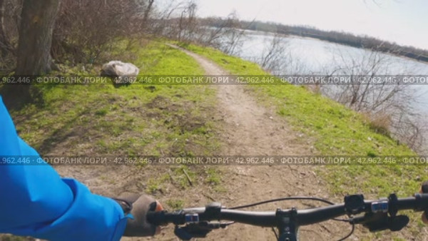 Прогулка на горном велосипеде по тропе рядом с рекой. Вид от первого лица. Замедленное движение. Любитель активного образа жизни и приключений на природе. Стоковое видео, видеограф Воловодов Владимир / Фотобанк Лори