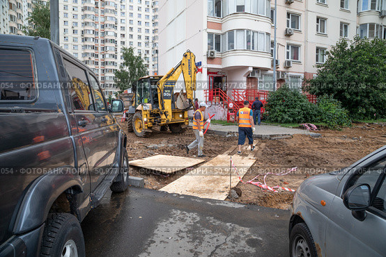 Производство земляных работ с нарушениями без установки ограждений в непосредственной близости от жилого дома и припаркованных автомашин. Москва, улица Большая Марфинская. Редакционное фото, фотограф Наталья Николаева / Фотобанк Лори