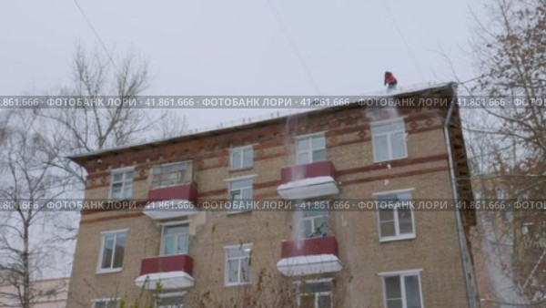 Рабочие сбрасывают снег с крыши дома (2023 год). Редакционное видео, видеограф Галина / Фотобанк Лори