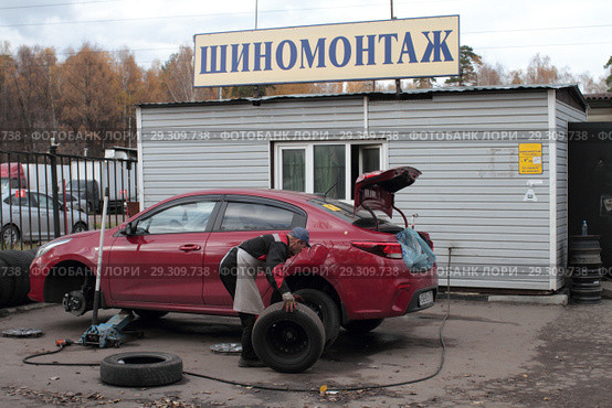 Рабочий шиномонтажа меняет колёса в Балашихе на улице Мира (2018 год). Редакционное фото, фотограф Дмитрий Неумоин / Фотобанк Лори