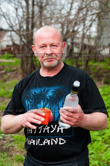 Радостный мужчина с бутылкой водки и стаканом на улице (2013 год). Редакционное фото, фотограф Игорь Низов / Фотобанк Лори