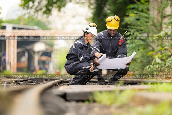 Railway technicians and engineers, Working on the train tracks at train station. Стоковое фото, агентство Ingram Publishing / Фотобанк Лори