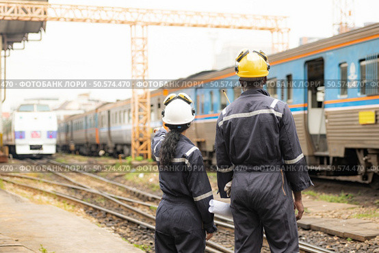 Railway technicians and engineers, Working on the train tracks at train station. Стоковое фото, агентство Ingram Publishing / Фотобанк Лори