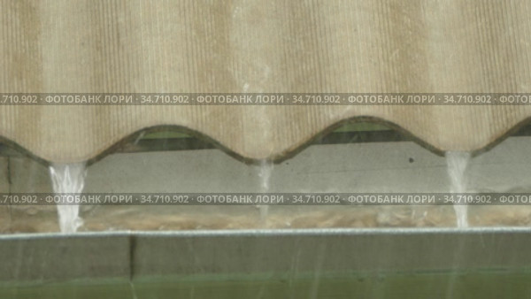 Rainwater pours from the undulating roof. Стоковое видео, видеограф Владимир Кравченко / Фотобанк Лори