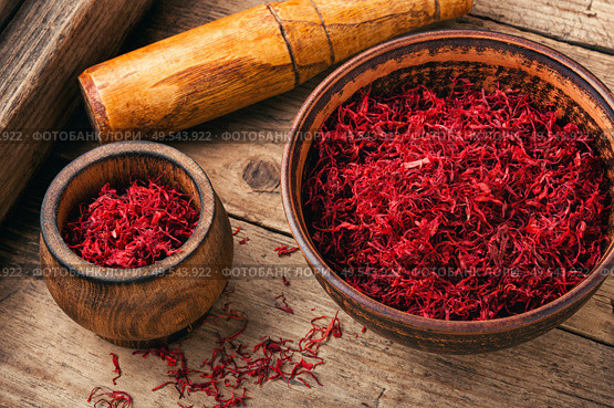 Raw organic red saffron spice on wooden background. Dried saffron spice. Стоковое фото, агентство Ingram Publishing / Фотобанк Лори