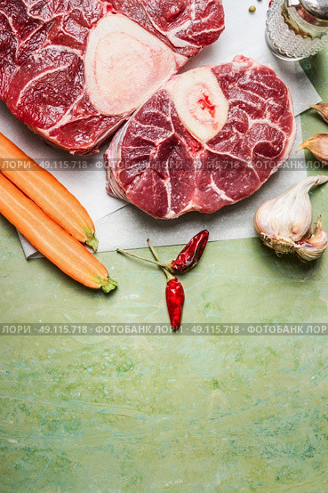 Raw veal shank meat and ingredients for Osso Buco cooking on rustic background, top view, vertical border. Стоковое фото, агентство Ingram Publishing / Фотобанк Лори