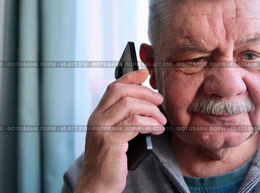 Разговор пенсионера с мошенниками. Fraud and deception. A shocked, worried elderly man in the process of talking to a scammer. Стоковое фото, фотограф Терехова Марина / Фотобанк Лори