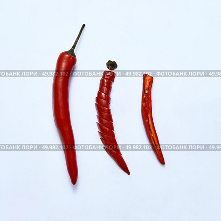Red chili pepper cut into slices as a version of slicing for cooking on a gray background, top view. sliced red chili or chilli cayenne pepper on a gray background, top view. Стоковое фото, агентство Ingram Publishing / Фотобанк Лори