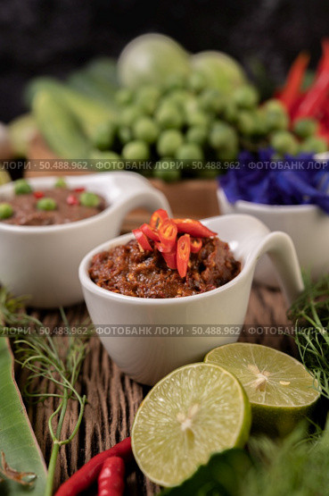 Red Eye Chili Paste with Lemon and Chili on Wooden Floor. Стоковое фото, агентство Ingram Publishing / Фотобанк Лори