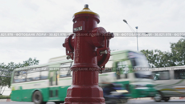 Red fire hydrant poles on street Ho Chi Minh city. Next to the road and passing cars and motorcycles. Vietnam. Редакционное фото, фотограф Mikhail Davidovich / Фотобанк Лори