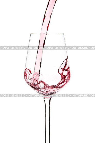 Red wine is pouring into a glass goblet on a white background. Стоковое фото, фотограф Restyler Viacheslav / Фотобанк Лори