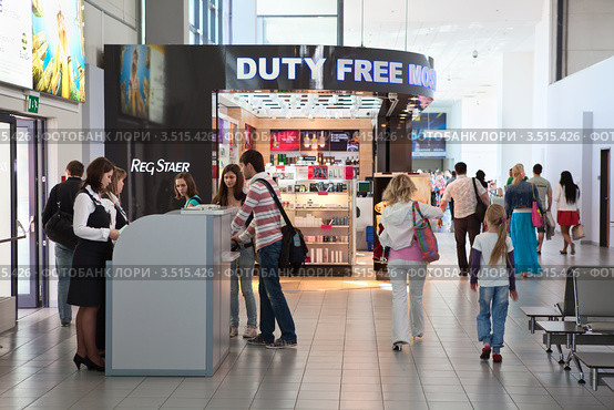 Регистрирующиеся на рейс пассажиры на фоне магазина Duty Free в аэропорту Шереметьево (2012 год). Редакционное фото, фотограф Кекяляйнен Андрей / Фотобанк Лори