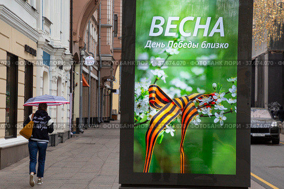 Рекламный баннер с надписью "Весна. День Победы близко" установлен на улице Большая Дмитровка в центре города Москвы, Россия (2022 год). Редакционное фото, фотограф Николай Винокуров / Фотобанк Лори
