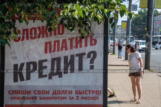 Рекламный баннер с предложением помочь в оформлении банкротства заемщику на автобусной остановке в городе Ярославле, Россия (2022 год). Редакционное фото, фотограф Николай Винокуров / Фотобанк Лори