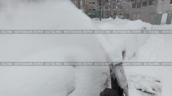 Removing snow with a snow blower. Winter work with the help of special equipment. Стоковое видео, видеограф Дмитрий Кобзев / Фотобанк Лори
