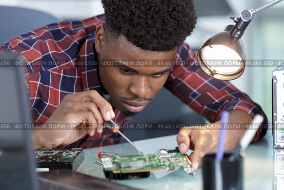 repairman disassembling smartphone with screwdriver. Стоковое фото, агентство Ingram Publishing / Фотобанк Лори