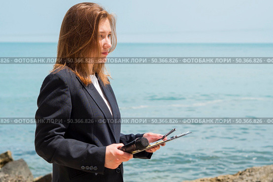 reporter holding notepad by sea. Стоковое фото, агентство Ingram Publishing / Фотобанк Лори