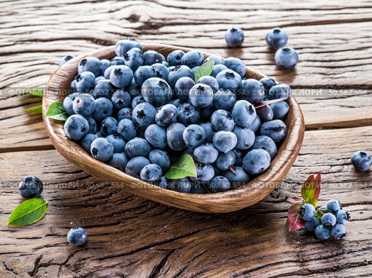 Ripe blueberries in the bowl on the wooden table. Стоковое фото, агентство Ingram Publishing / Фотобанк Лори