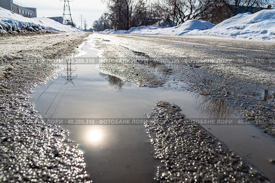 road with spring streams that flow along the road covered with ice and dense snow, reflection of sun, selective focus. Стоковое фото, фотограф Дмитрий Коростылев / Фотобанк Лори