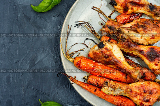 Roasted chicken drumsticks fried with vegetables. Copy space. Baked chicken drumstick, top view. Стоковое фото, агентство Ingram Publishing / Фотобанк Лори