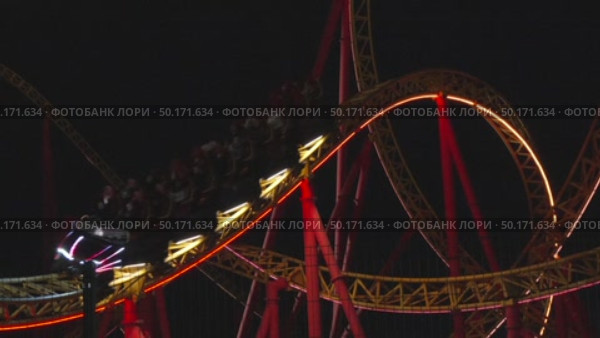 Rollercoaster Night Ride Amusement Park: Illuminated thrill ride traversing loops at night for entertainment. Стоковое видео, видеограф svetograph / Фотобанк Лори