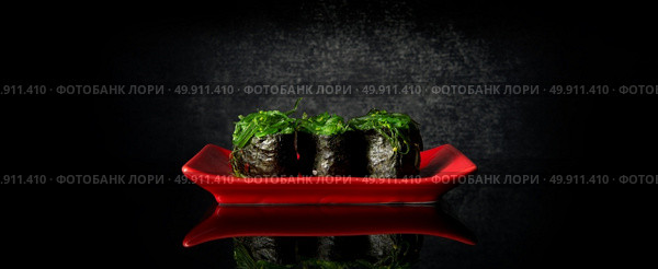 Rolls with chuka algae on red dish and black background. Стоковое фото, агентство Ingram Publishing / Фотобанк Лори
