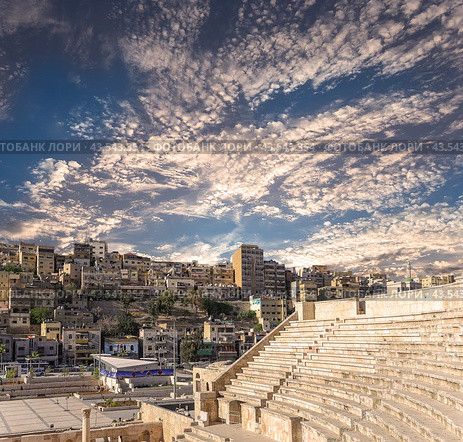 Roman Theatre in Amman, Jordan -- theatre was built the reign of Antonius Pius (138-161 CE), the large and steeply raked structure could seat about 6000 people. Against the sky with clouds (2016 год). Стоковое фото, фотограф Владимир Журавлев / Фотобанк Лори