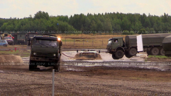 Российские армейские автомобили КАМАЗ (в том числе КАМАЗ "Выстрел") преодолевают водоем на армейском полигоне (2014 год). Редакционное видео, видеограф Арташес Оганджанян / Фотобанк Лори