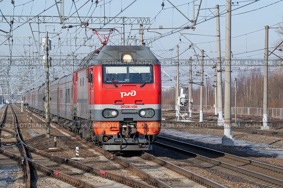 Российский электровоз ЭП2К-156 с пассажирским поездом "Санкт-Петербург - Москва"  солнечным мартовским днем. Октябрьская железная дорога (2024 год). Редакционное фото, фотограф Виктор Карасев / Фотобанк Лори