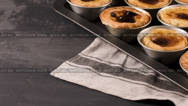 Rows of freshly cooked egg tarts, traditional portuguese dessert, pastel de nata, custard tarts on metal tray. Стоковое фото, агентство Ingram Publishing / Фотобанк Лори