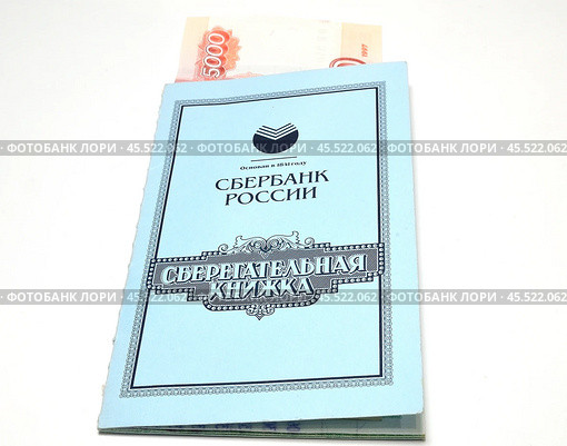 Рубли, вложенные в сберкнижку на белом фоне. Редакционное фото, фотограф Косиненко Юрий / Фотобанк Лори