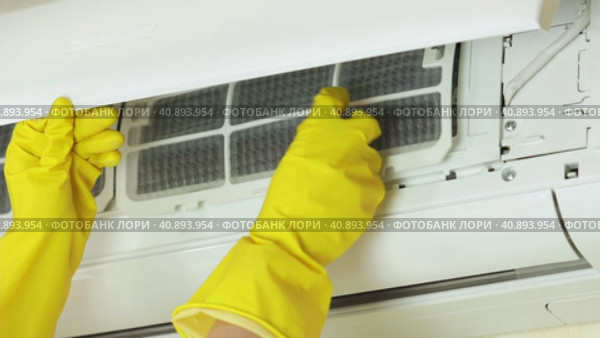 Руки в желтых перчатках открывают переднюю крышку кондиционера и извлекают воздушный фильтр для очистки. Концепт домашней работы или работы технического специалиста сервисной компании. Стоковое видео, видеограф Светлана Ельцова / Фотобанк Лори