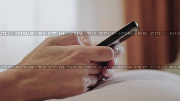Руки женщины на белой подушке, держащего телефон. Стоковое видео, видеограф Valeryi Vysotkov / Фотобанк Лори