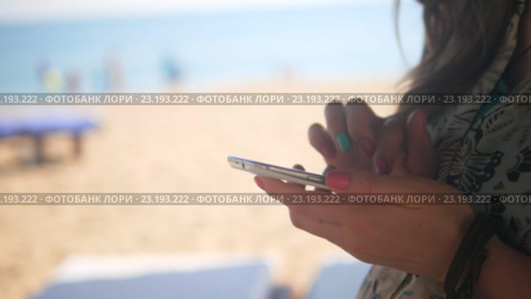Руки женщины, пользующейся смартфоном на пляже. Стоковое видео, видеограф Павел Котельников / Фотобанк Лори